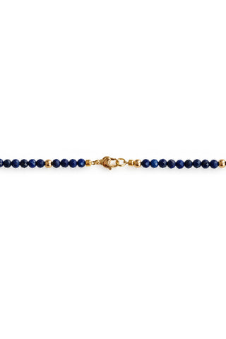 Close up of gold clasp on blue lapis beaded necklace on white background
