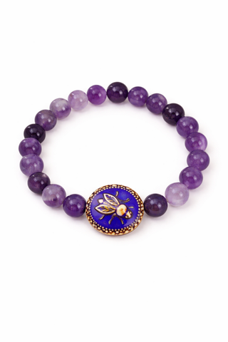 Purple amethyst beaded bracelet with a round bee charm on a white background