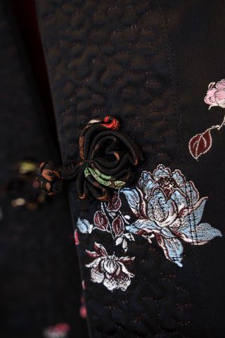Close-up of embroidered brocade design on a dark fabric background
