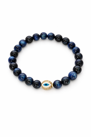 Blue tigers eye beaded bracelet with a gold evil eye charm on a white background