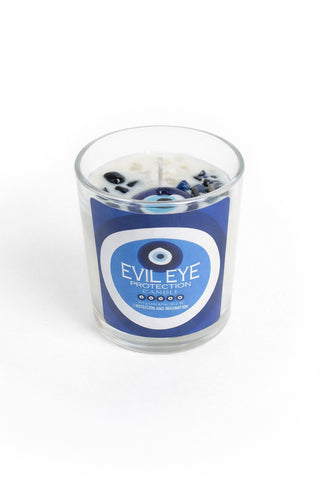 Candle in a glass jar with an 'Evil Eye Protection' label on a white background