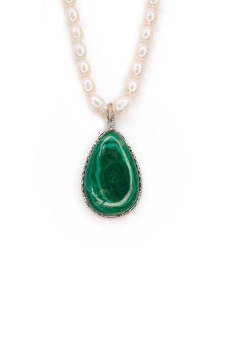 Teardrop-shaped green malachite pendant on a white pearl necklace against a white background