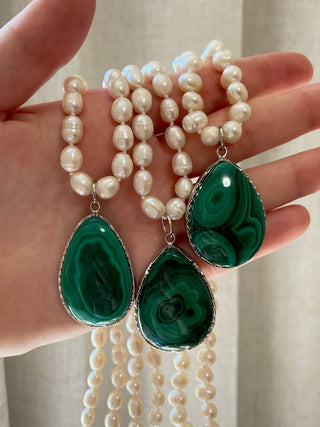 Three pearl necklaces with green malachite teardrop shaped pendants.