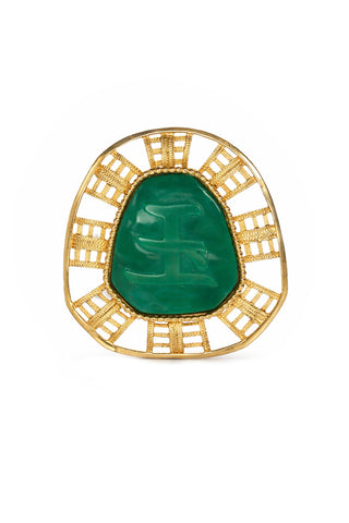 Gold brooch with a green stone on a white background