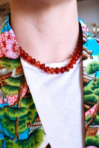 Person wearing a carnelian necklace and a coloful kimono.