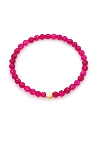Pink beaded bracelet with a gold heart charm on a white background