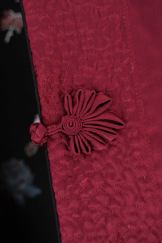 Maroon fabric with button detail.