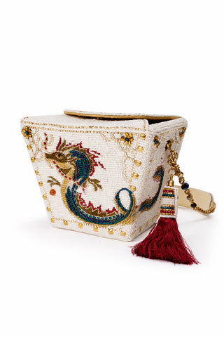 Beaded dragon purse with red tassel on a white background