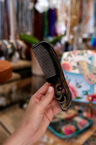 Hand holding ox horn comb