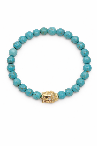 Turquoise beaded bracelet with a gold Buddha charm on a white background
