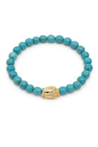 Turquoise beaded bracelet with a gold Buddha charm on a white background