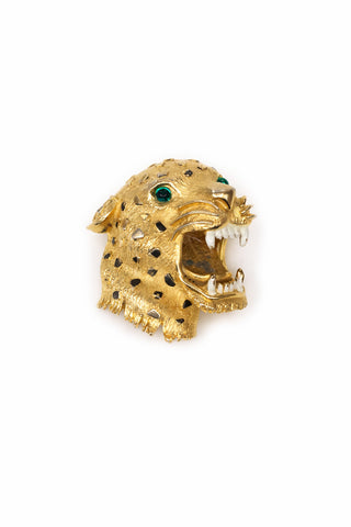 Gold leopard head brooch with green eyes on a white background