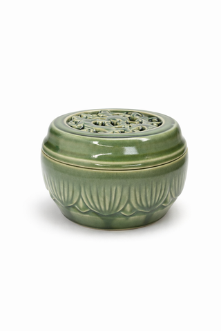 Green ceramic incense burner with intricate design on a white background