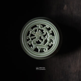 Decorative ceramic top with intricate design on a dark background, featuring the brand 'Hiem Van Ceramics'.