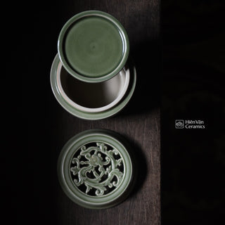 Green ceramic container with intricate design on a dark surface, featuring Hiánván Ceramics logo.